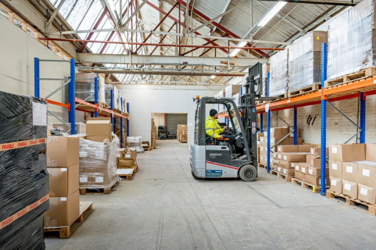 forklift drivers moving boxes in warehouse
